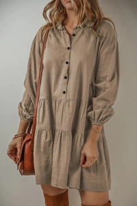Détail de robe à manches longues unie avec ourlet à volants étagés et boutonnage avant