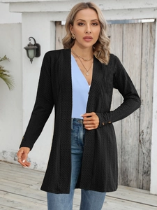 Close-up of black textured knit cardigan featuring elegant gold buttons on the sleeve cuffs