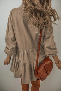 Détail d'une robe à volants kaki en coton-lin avec sac à bandoulière en cuir et boucles