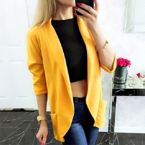 Detail of bright yellow longline blazer with notch lapel and functional side pockets