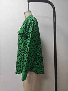 Detail of green leopard print corduroy jacket featuring a buttoned pocket and ribbed texture