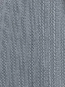 Close-up detail of grey knitted cardigan fabric with vertical cable knit texture