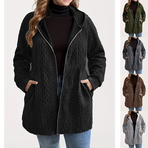 Detail of knit hoodie featuring textured cable pattern and functional front pockets