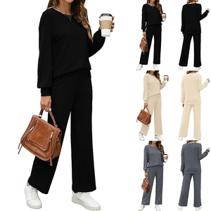 Detail view of the long sleeve round neck top and wide leg pants in black, beige and grey