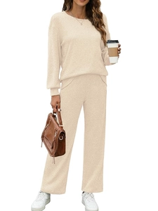 Detail of apricot knitted two-piece set featuring a long-sleeve crewneck top and straight pants