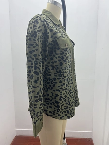 Close-up of olive green corduroy jacket with black leopard print and chest pocket detail