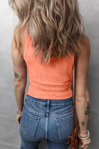 Vue arrière d'un débardeur en maille côtelée orange vif porté avec un jean en denim bleu
