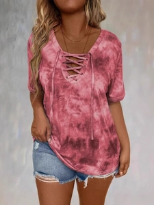 Dettaglio della maglietta tie-dye rosa intenso con scollo a V e lacci intrecciati