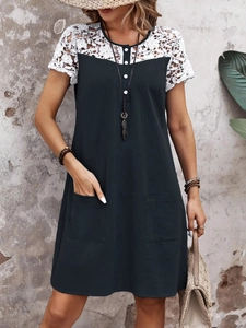 Detail of white lace crochet patchwork and button front on a casual navy dress