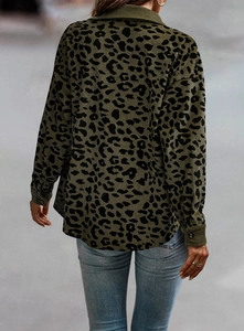 Detailed texture of olive green corduroy jacket with black leopard print and button cuffs