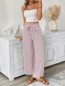 Detail of high waist striped trousers featuring an elastic waistband and chic bow tie ribbon