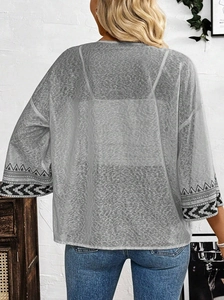 Détail de l'imprimé géométrique sur les poignets d'un cardigan gris à motif léopard
