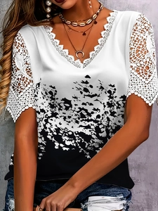 Detailed view of the V-neck lace patchwork and abstract black floral print on white top