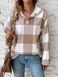 Detail of hooded plaid sweatshirt with V-neck button closure and brown checkered pattern