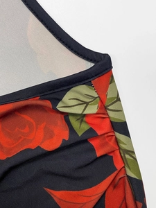 Macro view of floral print fabric with red roses and fine stitching on the black dress
