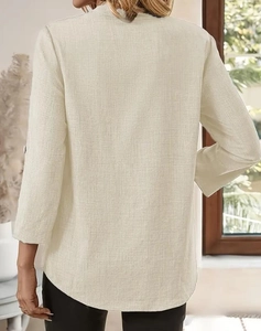 Detail view of light beige cotton linen shirt back featuring curved hem and textured fabric