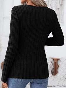 Detail of black ribbed knit long sleeve top showing slim fit texture and fabric quality