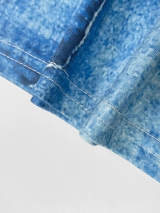 Detailed close-up of double-needle stitching on blue printed plus size jumpsuit fabric