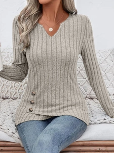 Detail of grey ribbed knit sweater featuring V-neckline and decorative side buttons