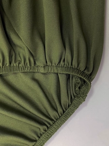 Detail shot of olive green elastic waistband with precise stitching on knit fabric