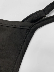Close-up of adjustable shoulder strap and stitching detail on a black knit dress