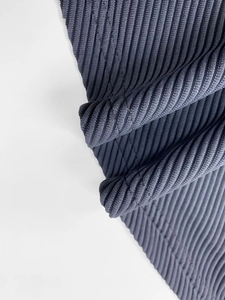 Detailed macro view of the soft ribbed corduroy fabric texture in deep blue grey