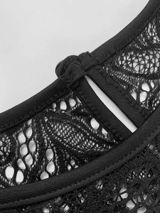 Detail of elegant black lace dress featuring a delicate keyhole back and button closure