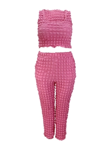 Dettaglio del tessuto rosa a nido d'ape del completo con top corto e pantaloni