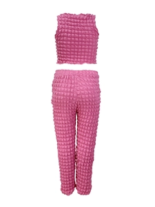 Dettaglio del tessuto rosa testurizzato popcorn sul set da donna a due pezzi con pantaloni