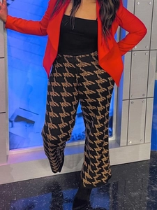 Detail of flared knitted pants with a brown and black houndstooth pattern and wide-leg fit