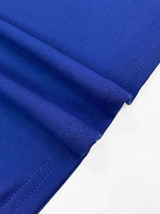 Detail shot of the navy blue dress featuring durable double-needle stitching on the hem