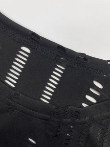 Détail de la maille ajourée noire et des coutures plates sur le legging ajusté