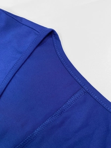 Close-up of the royal blue knit dress neckline showing precise double-needle stitching detail