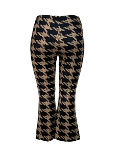 Macro detail of high-waist flared pants with beige geometric woven pattern on black fabric