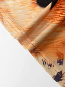 Close-up of double-needle coverstitch hem on orange tiger print knit dress fabric