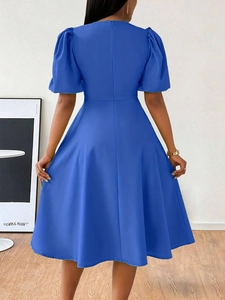 Detail view of the elegant Klein blue dress showing hidden back zipper and puff sleeves