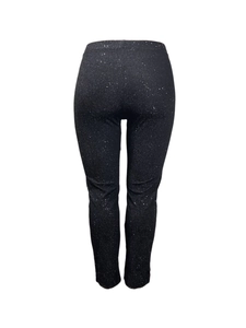Detail of slim fit black leggings featuring shimmering silver glitter texture fabric