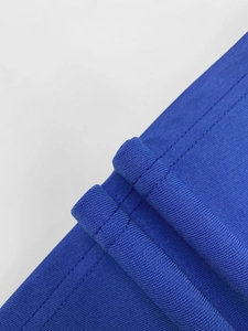 Detailed macro view of royal blue knit fabric showing fine texture and double stitching