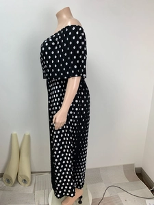 Detailed view of accordion pleats on black and white polka dot off-shoulder maxi dress