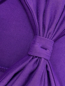 Détail macro du tissu tricoté violet montrant la structure plissée et le design froncé