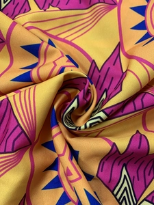 Macro detail of colorful floral geometric print fabric with silky texture and drape