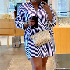 Detail of blue and white vertical striped long sleeve shirt dress with white buttons