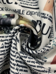 Primer plano de tela con estampado de periódico, caída suave y texto monocromático