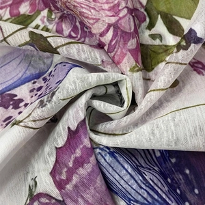 Close-up of floral and bird print fabric with lightweight linen texture and vibrant colors