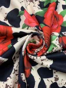 Macro shot of fabric texture with red rose print and classic cow spots pattern