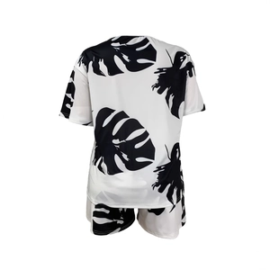 Rear view of two-piece summer set with green monstera leaf print on white fabric