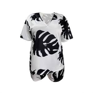 Flat lay of summer two-piece set featuring V-neck top and tropical leaf print shorts