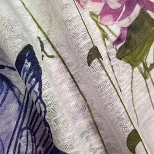Detail of lightweight semi-transparent mesh fabric with purple flowers and blue butterflies