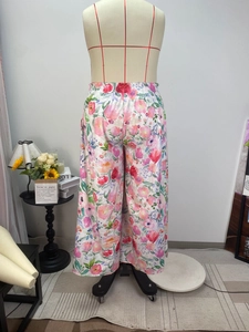 Detail of high waist elastic waistband on colorful floral wide-leg trousers for women