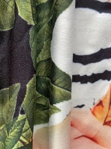 Vue macro du tissu en satin avec imprimés floraux et tigre et détails soyeux